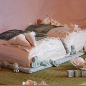 Dåpskake – Bok med bilder, blomster og dåpsbarnet sovende i en calla